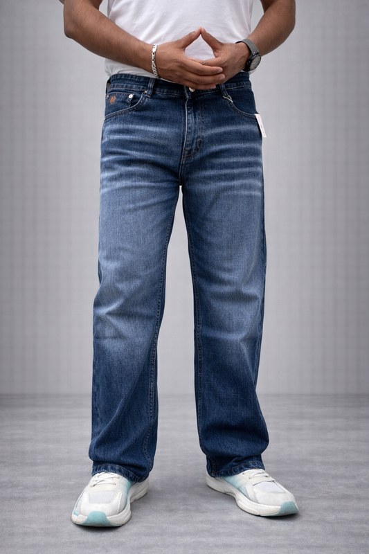 Indigo straight-fit denim jeans, front view of button waistband and fly with relaxed legs.