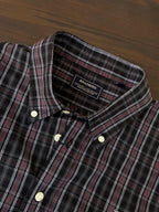Dark plaid shirt neckline and inner collar label, cream buttons, red/white tartan stripes
