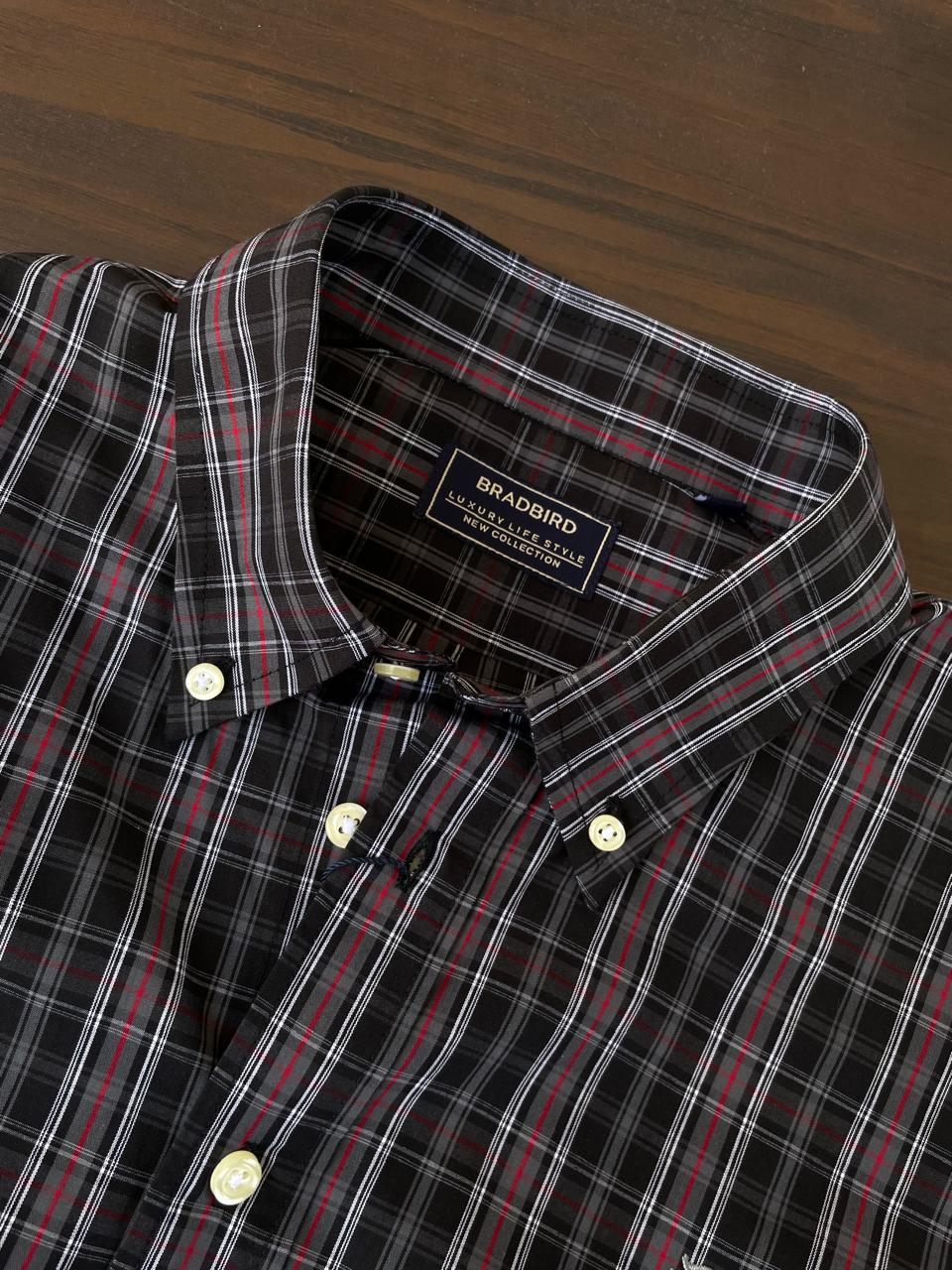 Dark plaid shirt neckline and inner collar label, cream buttons, red/white tartan stripes