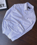 Folded light blue micro-check button-down shirt with tag, spread collar, long sleeves