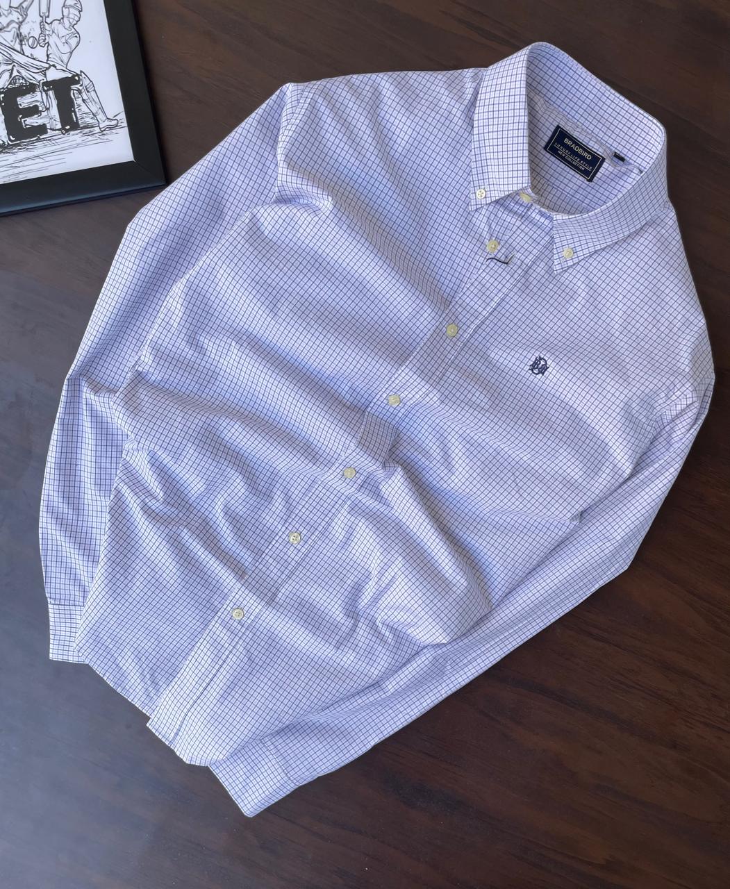 Folded light blue micro-check button-down shirt with tag, spread collar, long sleeves
