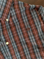 Close-up of tartan plaid shirt pocket and buttons, tan and slate grey with white lines