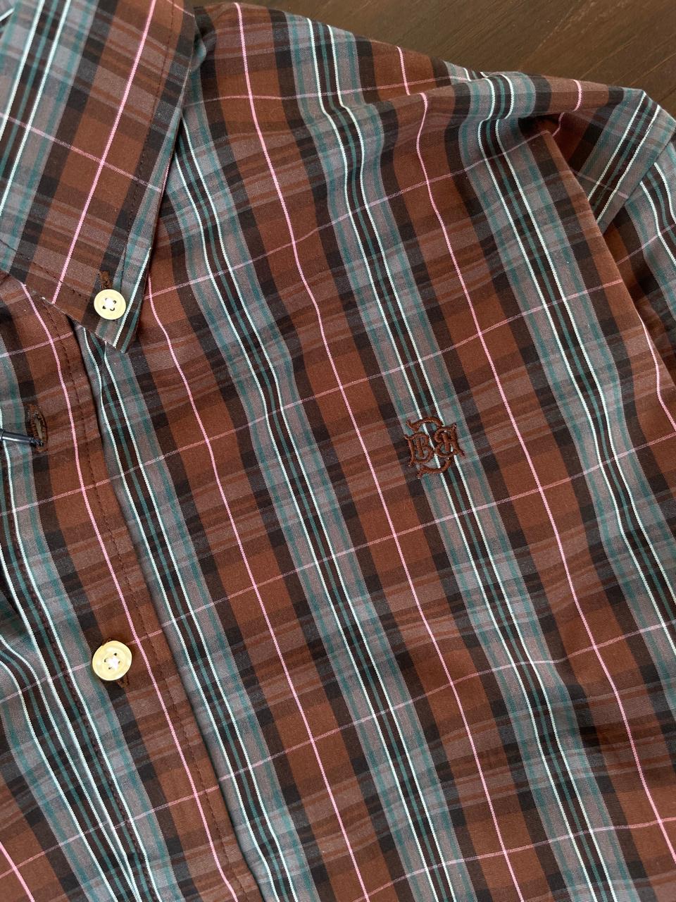Close-up of tartan plaid shirt pocket and buttons, tan and slate grey with white lines