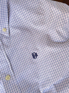Light blue micro-check shirt with navy-style chest emblem and yellowish buttons