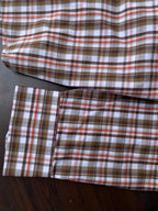 Brown, orange, and white plaid long sleeves with button cuffs, laid flat