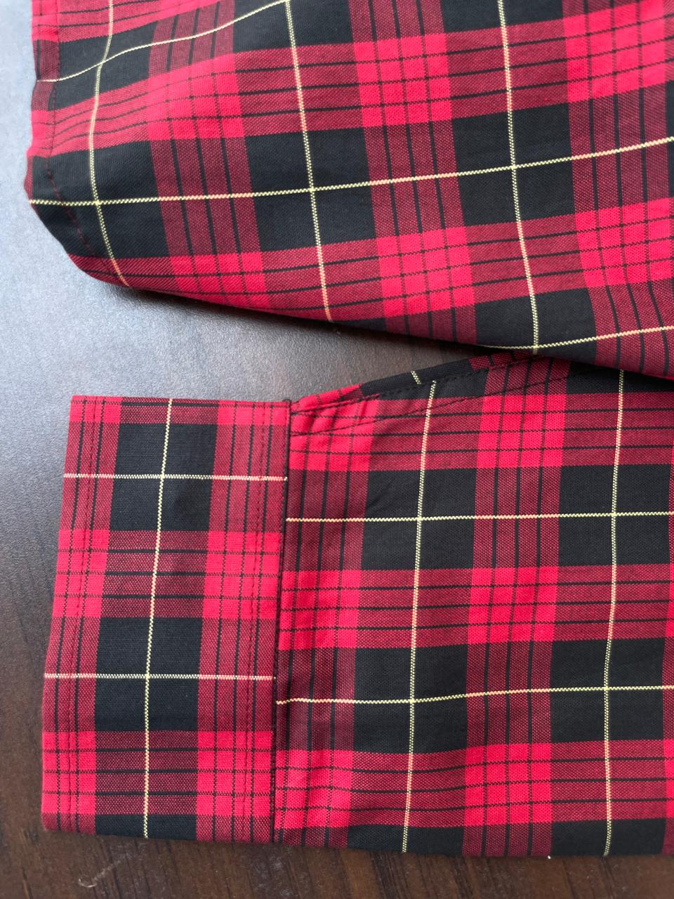 Red and black buffalo check cuffs and hem, button closure detail