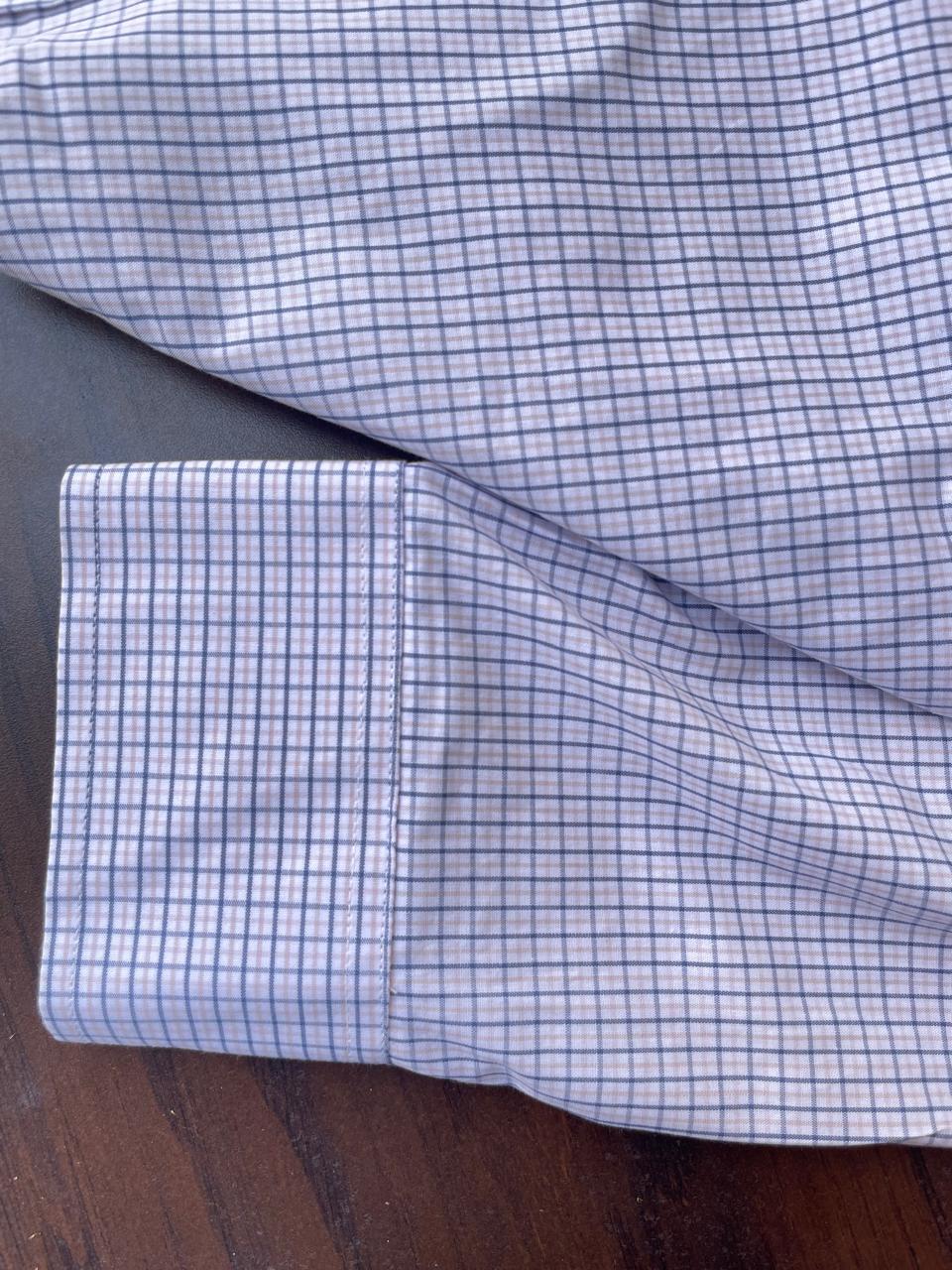Light blue micro-check shirt sleeve cuff and hem detail, visible stitching