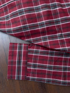 Maroon tartan check shirt sleeve cuff with white button and striped band