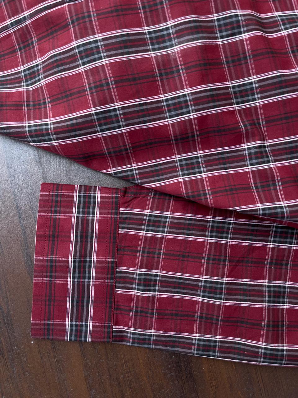 Maroon tartan check shirt sleeve cuff with white button and striped band