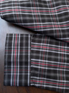 Dark plaid shirt cuff and hem detail, red/white stripes, folded for display