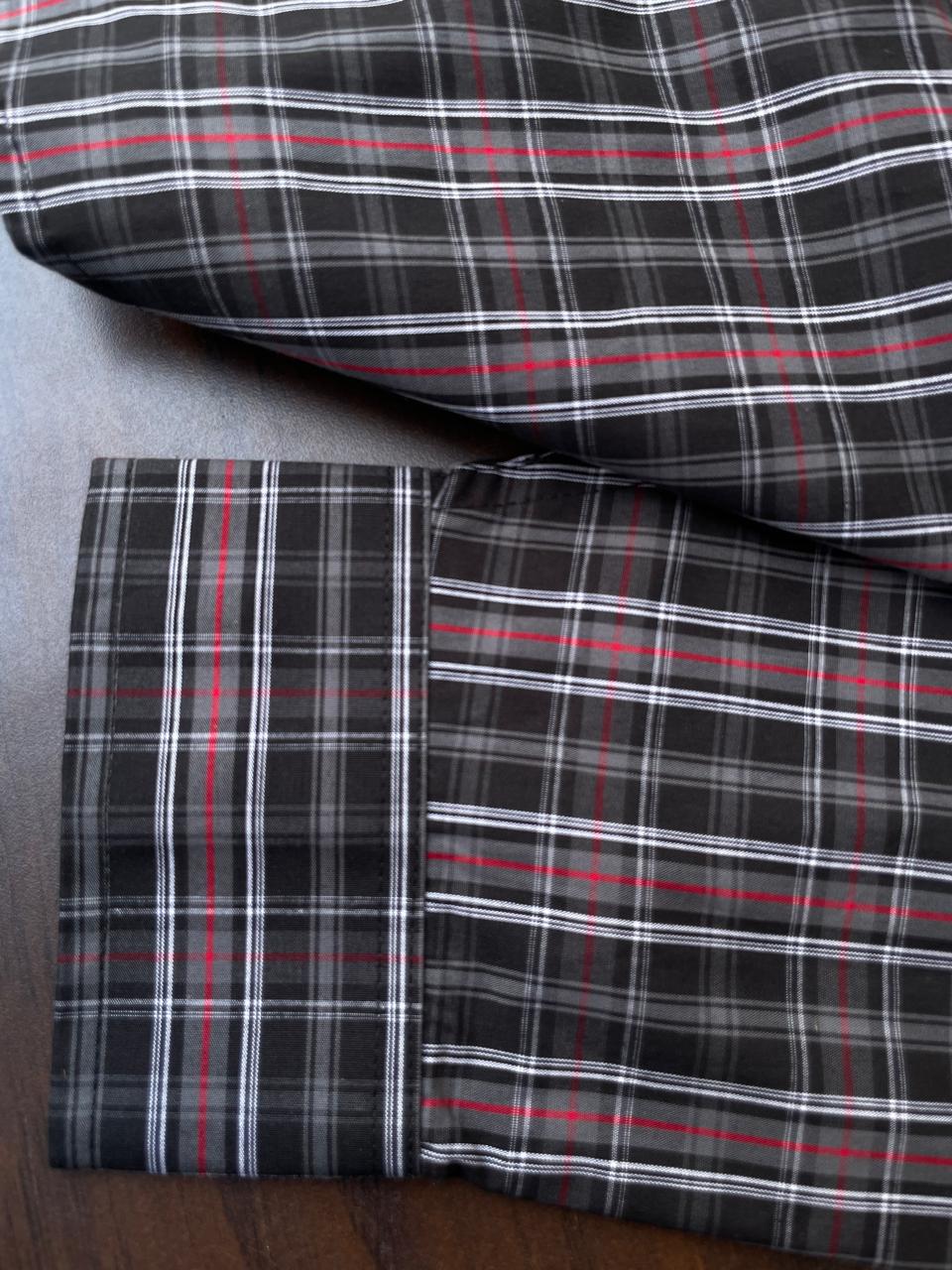 Dark plaid shirt cuff and hem detail, red/white stripes, folded for display