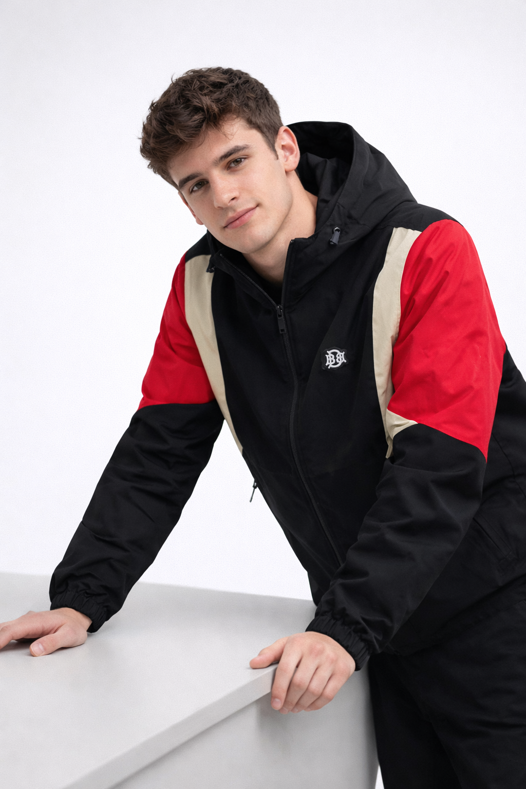 Black hooded windbreaker with red and sand multi-panel sleeves and chest, full zip front