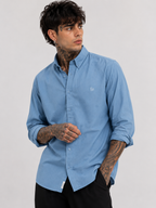 Indigo-blue oxford shirt with button-down collar and tonal monogram on chest.
