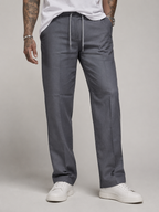 Dark grey linen trousers with drawstring waist and tapered straight legs