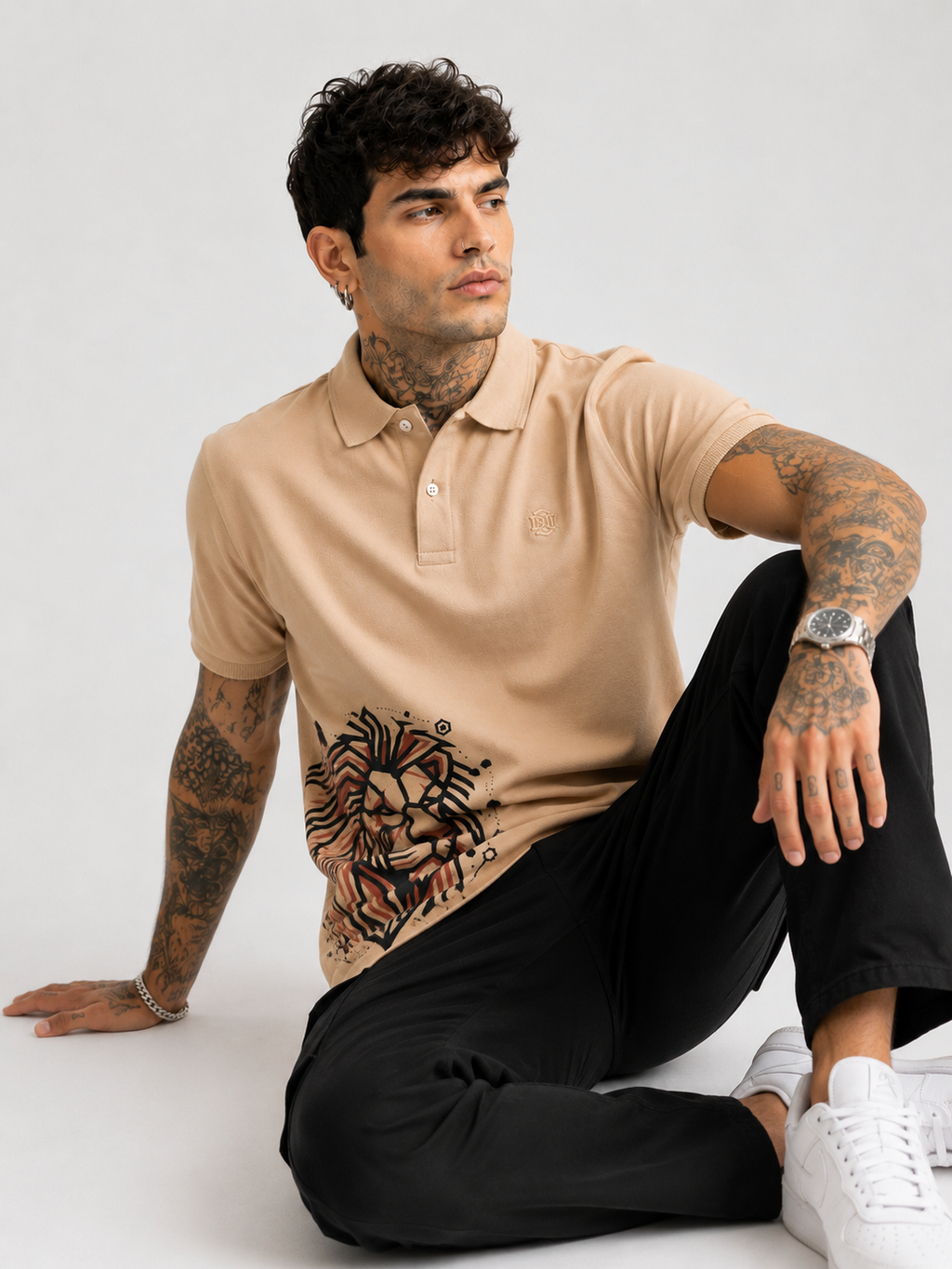 Beige polo shirt with lion graphic on hemline, short sleeves and button collar
