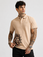 Beige polo shirt with lion graphic on front, short sleeves and button collar
