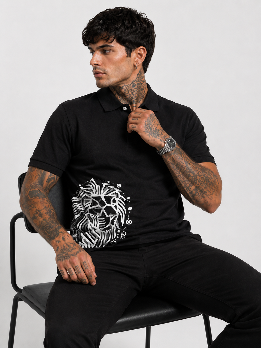Black polo shirt with lion graphic on chest, short sleeves, buttoned collar