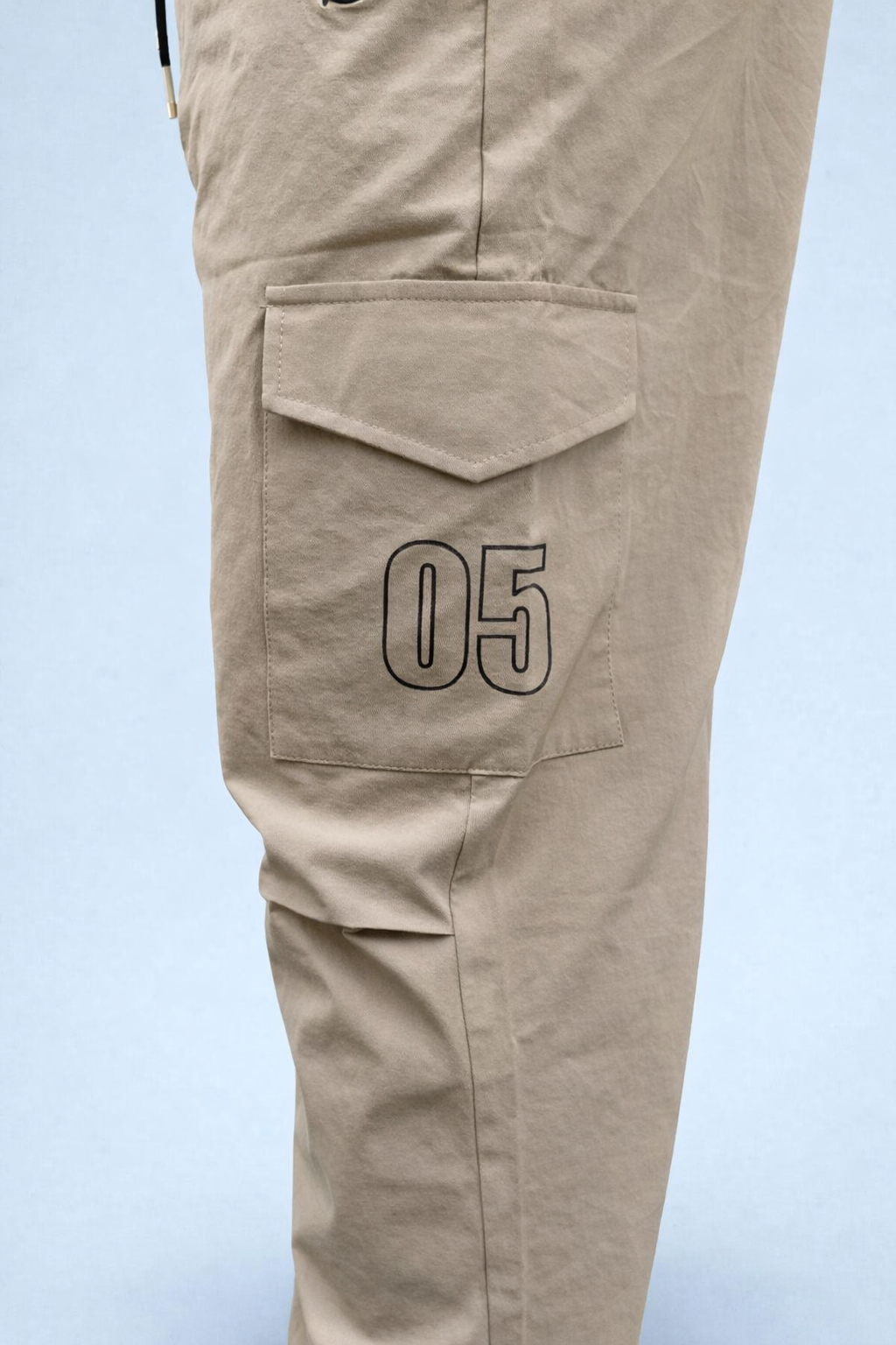 Beige cargo joggers with flap side pocket and '05' printed patch