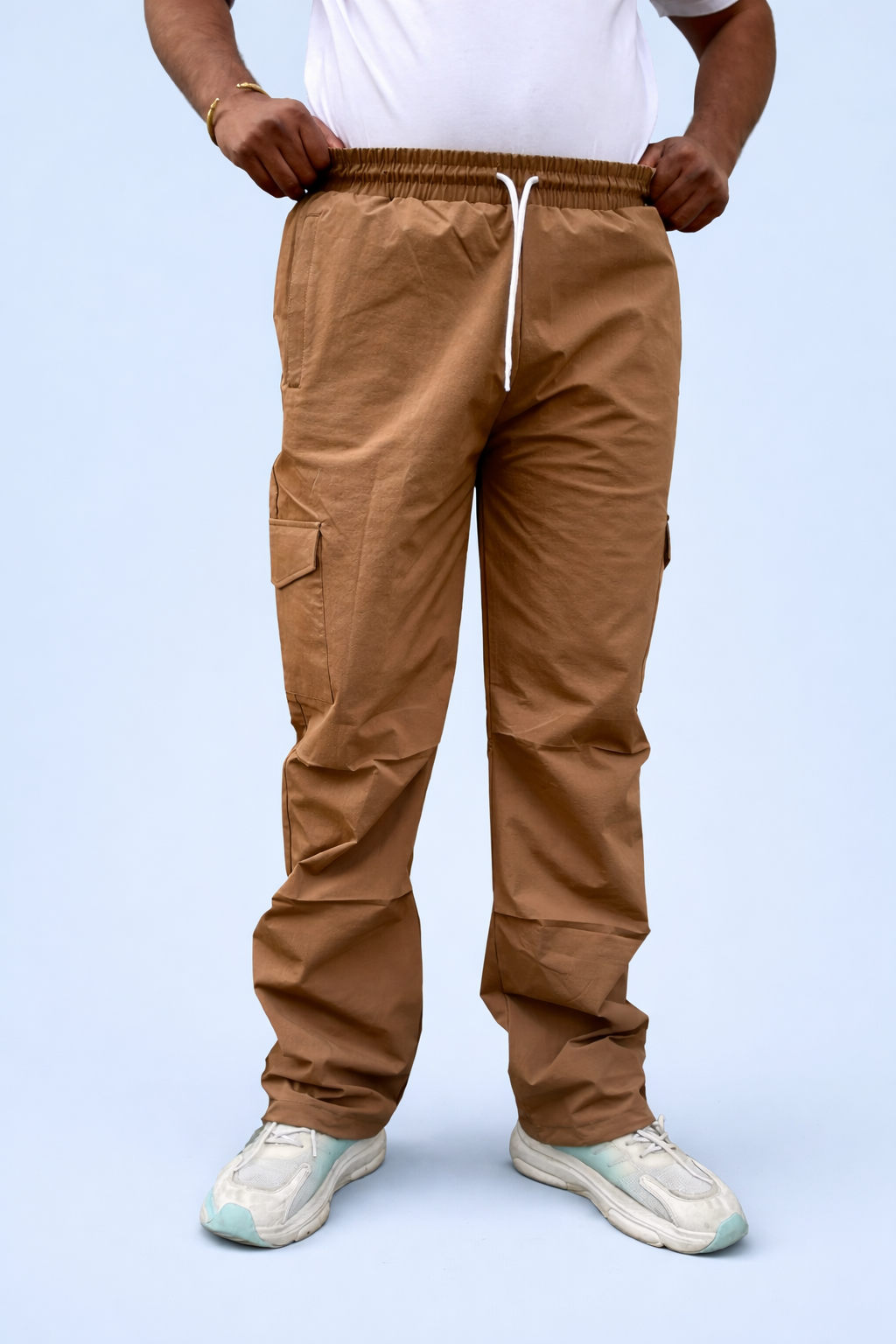 Brown cargo joggers on model, drawstring waist and multiple cargo pockets at legs