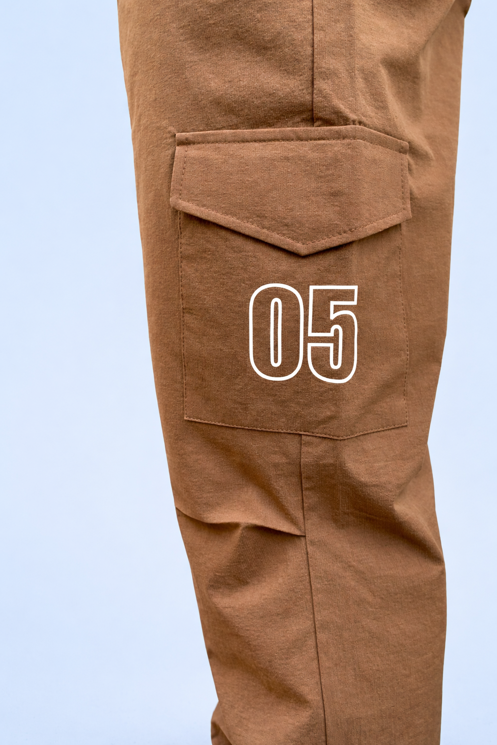 Brown cargo joggers with flap pocket and large “05” graphic on leg