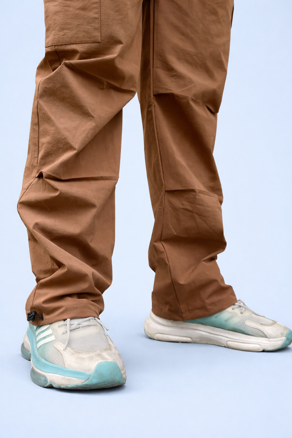Brown cargo joggers featuring cargo pocket panels and elastic ankle cuff drawcord