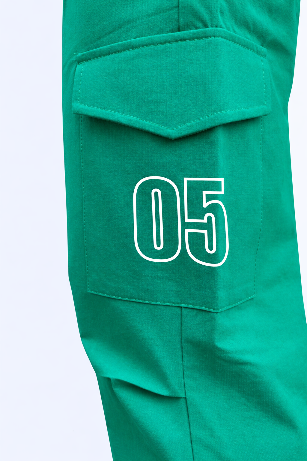 Green cargo joggers close-up: 05 number patch on cargo pocket