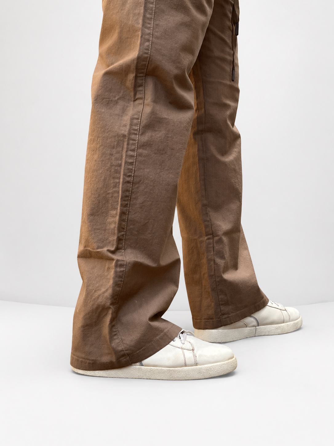 Brown drawstring pants close-up: stitched side seams, relaxed wide legs, ankle hem