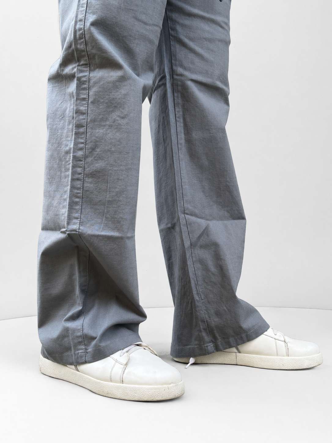 Close-up: light grey wide-leg drawstring pants with stitched seams and hems