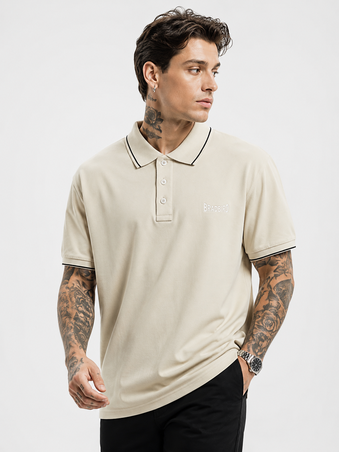 Cream polo shirt with navy-trim collar edge, button placket, Bradbird chest logo.