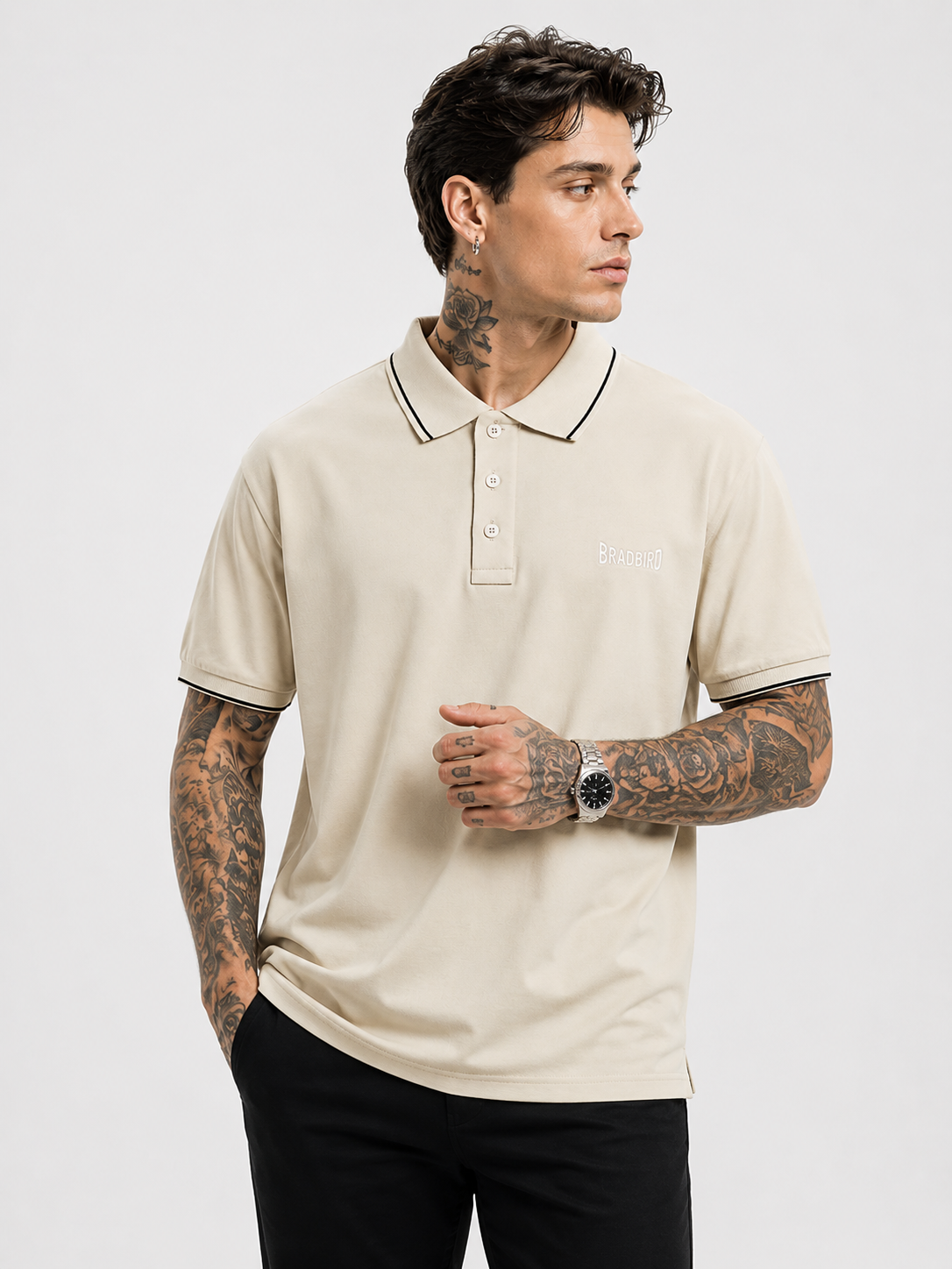 Cream polo shirt with navy-trim collar, button placket, Bradbird logo on chest.