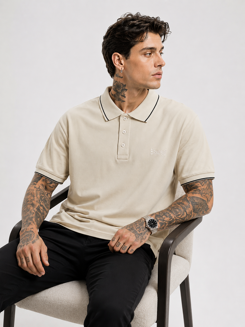 Cream polo shirt with navy-trim sleeve cuffs and collar, Bradbird logo on chest.