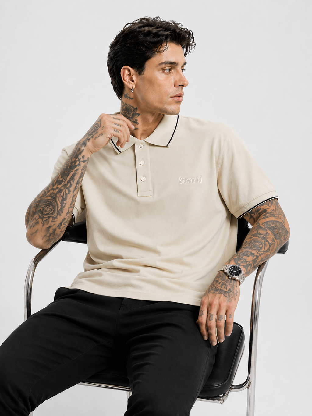 Cream polo shirt with navy-trim collar and cuffs, Bradbird logo, short sleeves.