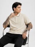 Cream polo shirt with navy-trim collar and cuffs, Bradbird logo, short sleeves.