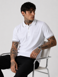 White polo shirt worn with black-trim collar and sleeve cuffs, short sleeves and button placket.