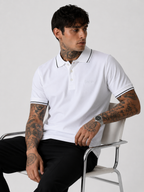 White polo shirt worn with black-trim collar and sleeve cuffs, short sleeves and button placket.