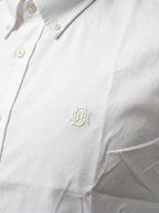 White oxford shirt close-up with tonal monogram on textured fabric