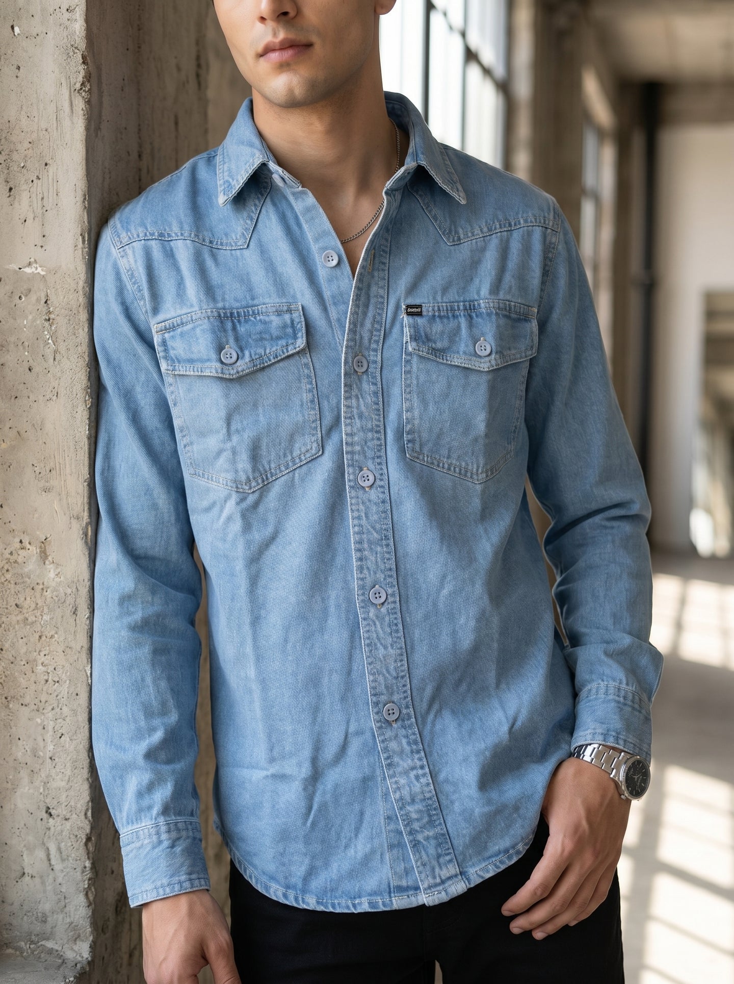 Light blue denim shirt front with pointed collar and two chest flap pockets