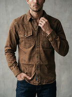 Brown denim western shirt with pointed collar, flap chest pockets, and snap cuffs.