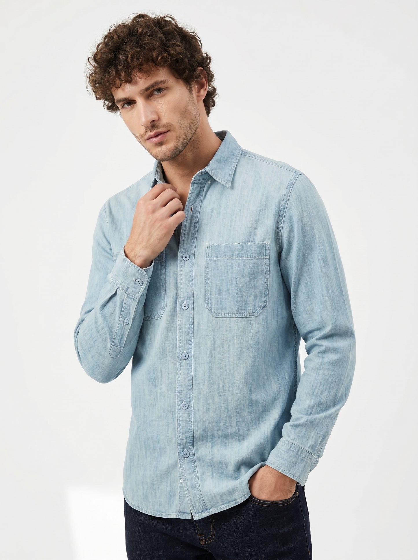 Light blue denim button-down shirt with two chest pockets and long sleeves