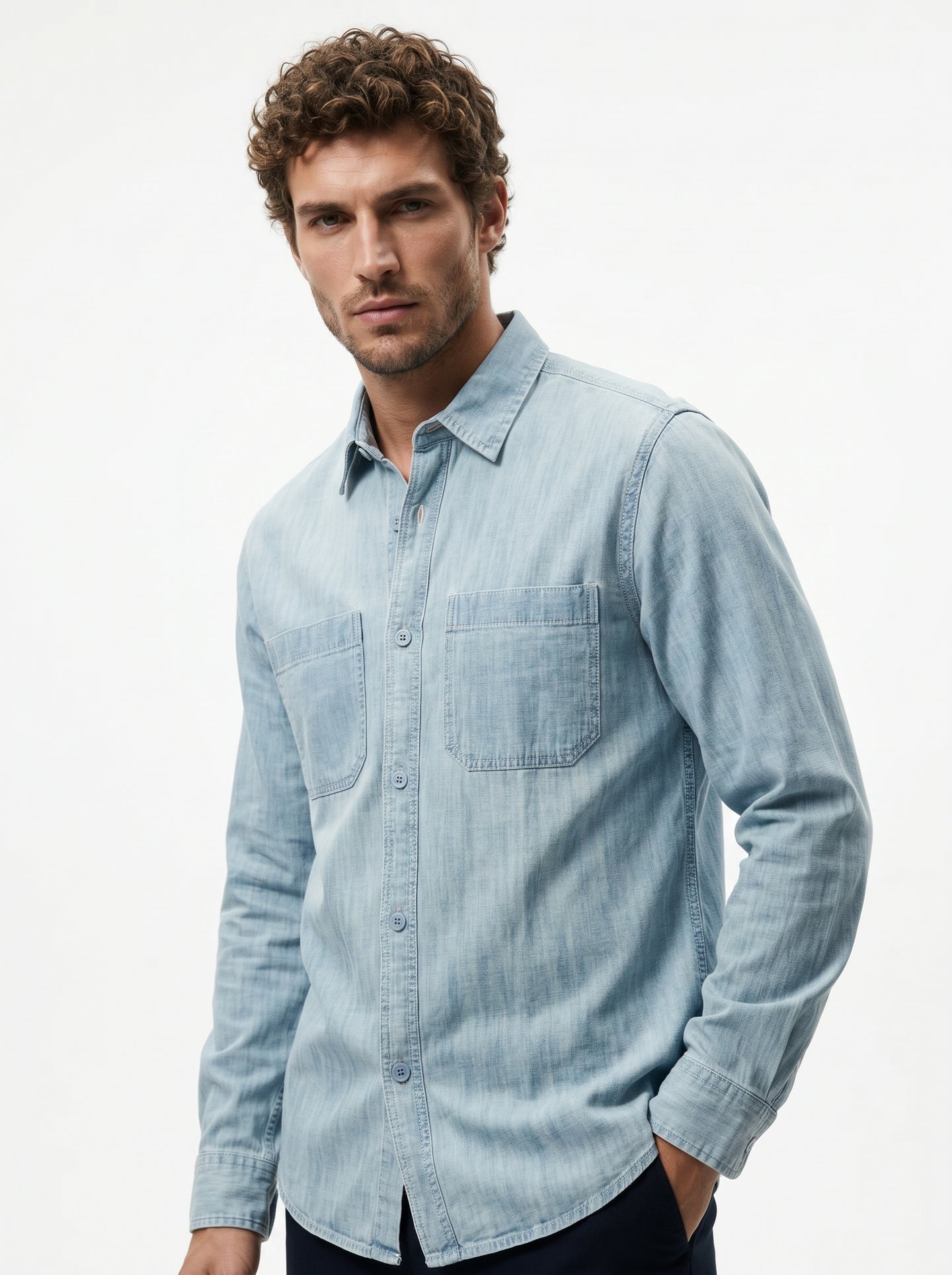 Light blue denim long-sleeve button-up shirt with chest pocket and curved hem