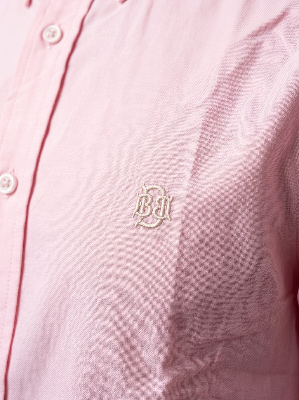 Light pink textured oxford shirt with small tonal monogram logo near chest