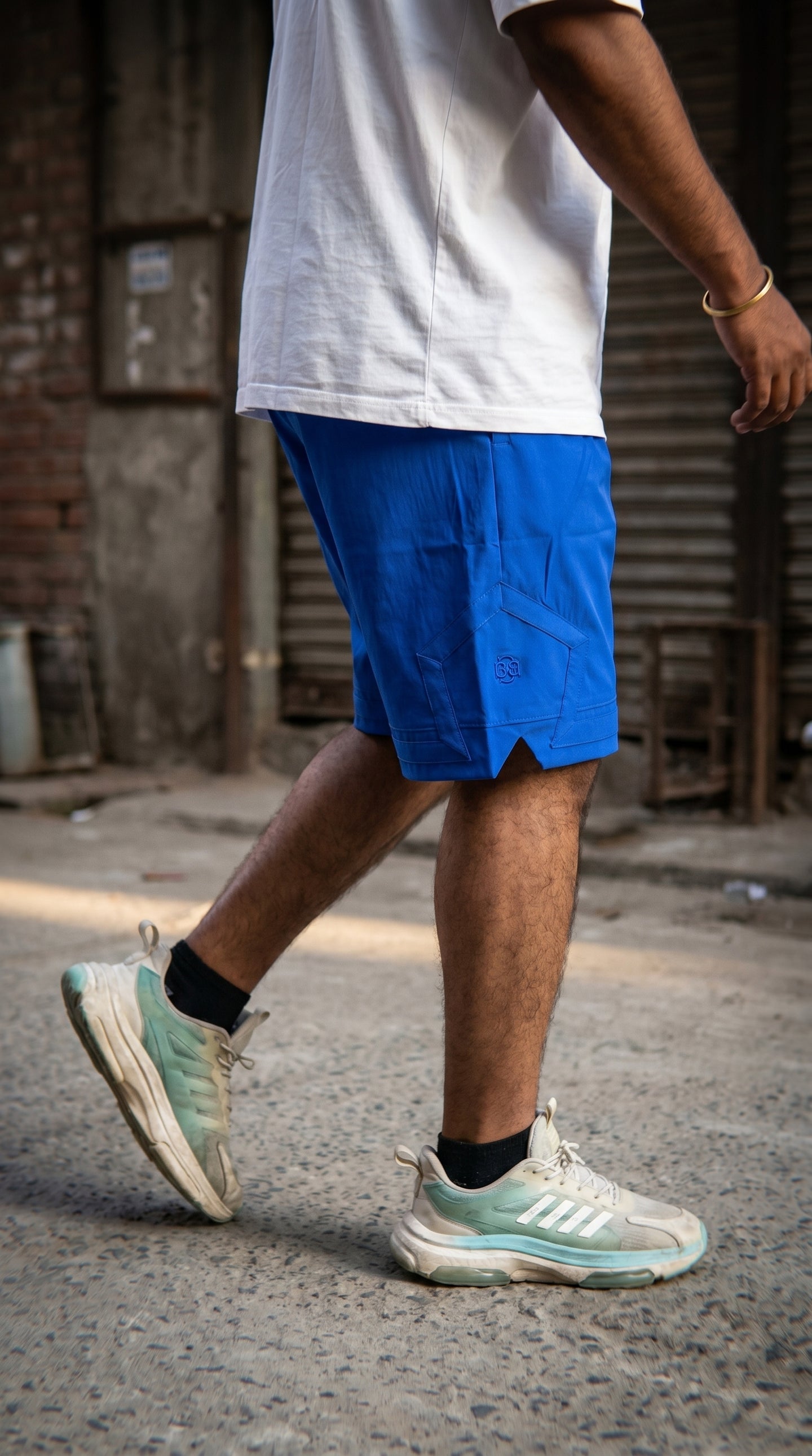 Blue cargo shorts with pentagonal pocket and embroidery, side view