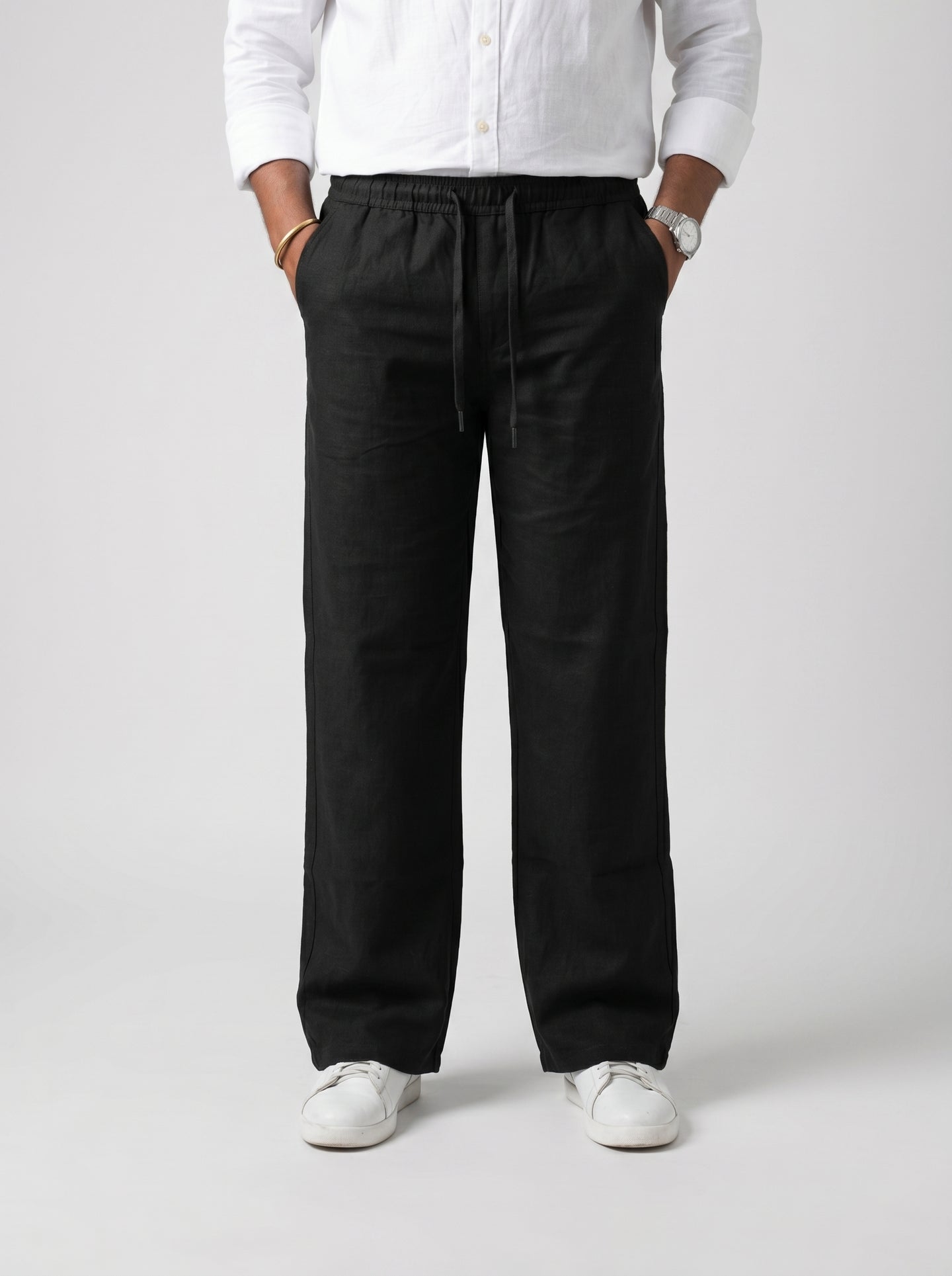 Black relaxed drawstring pants with elastic waistband, front pleats, cuffed hems