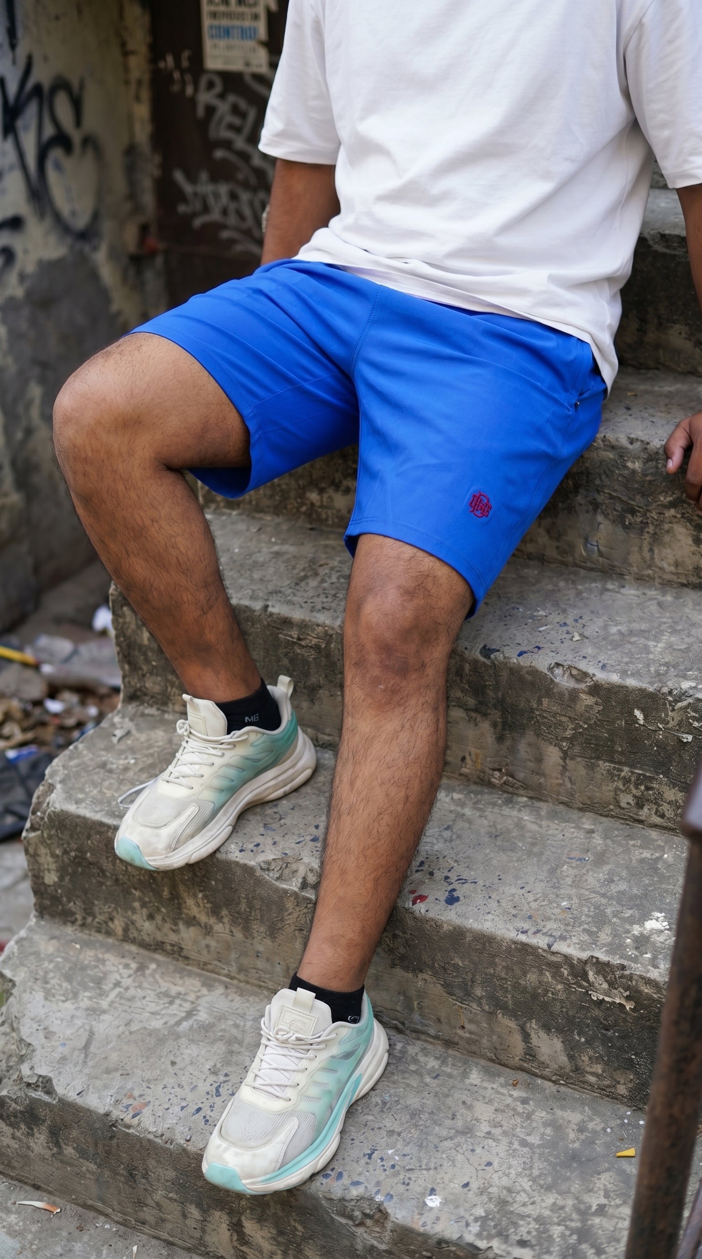Blue tech shorts with small red logo, relaxed fit, above-knee length