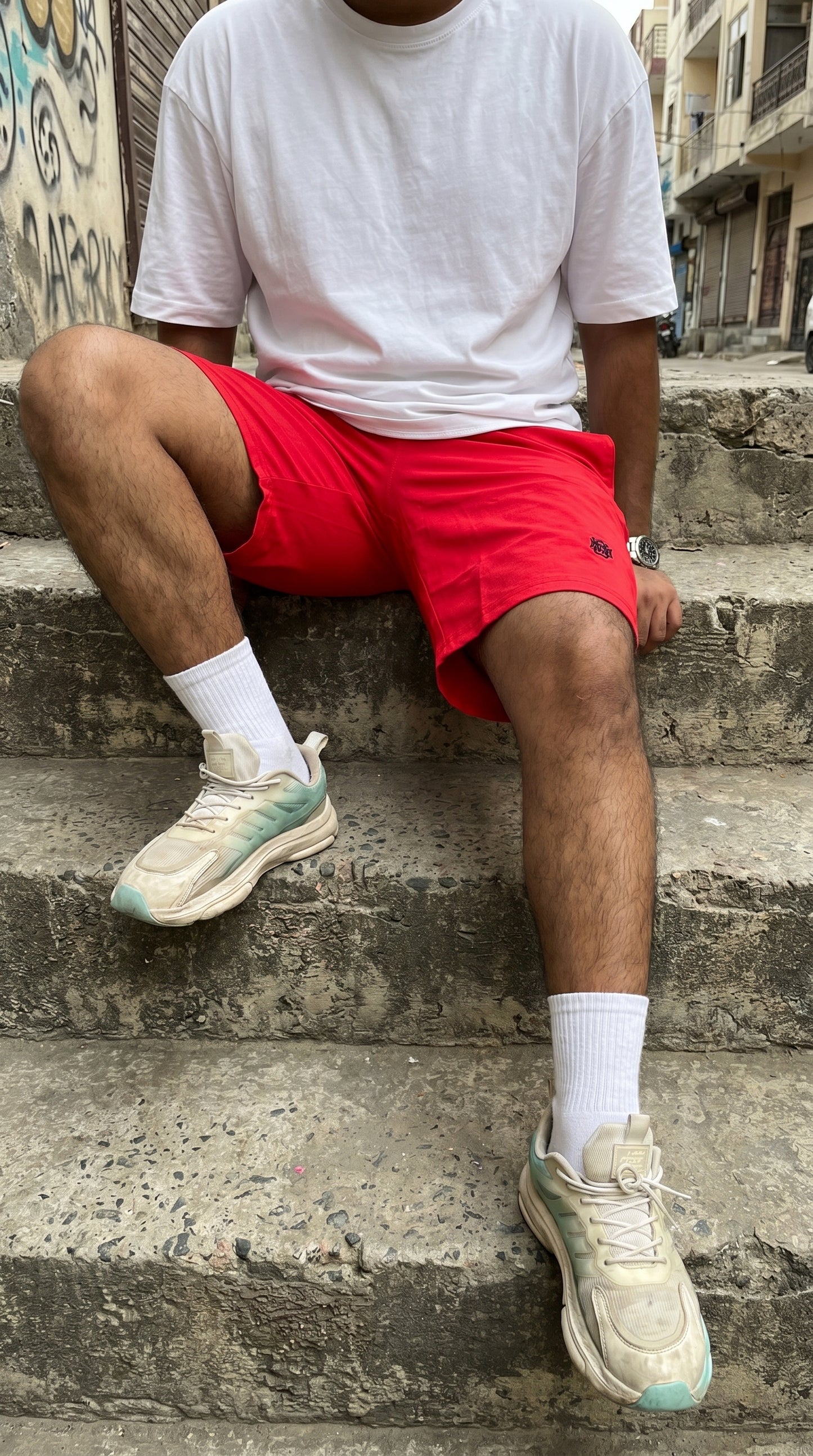 Red tech shorts with drawstring waistband and side pocket, mid-thigh length