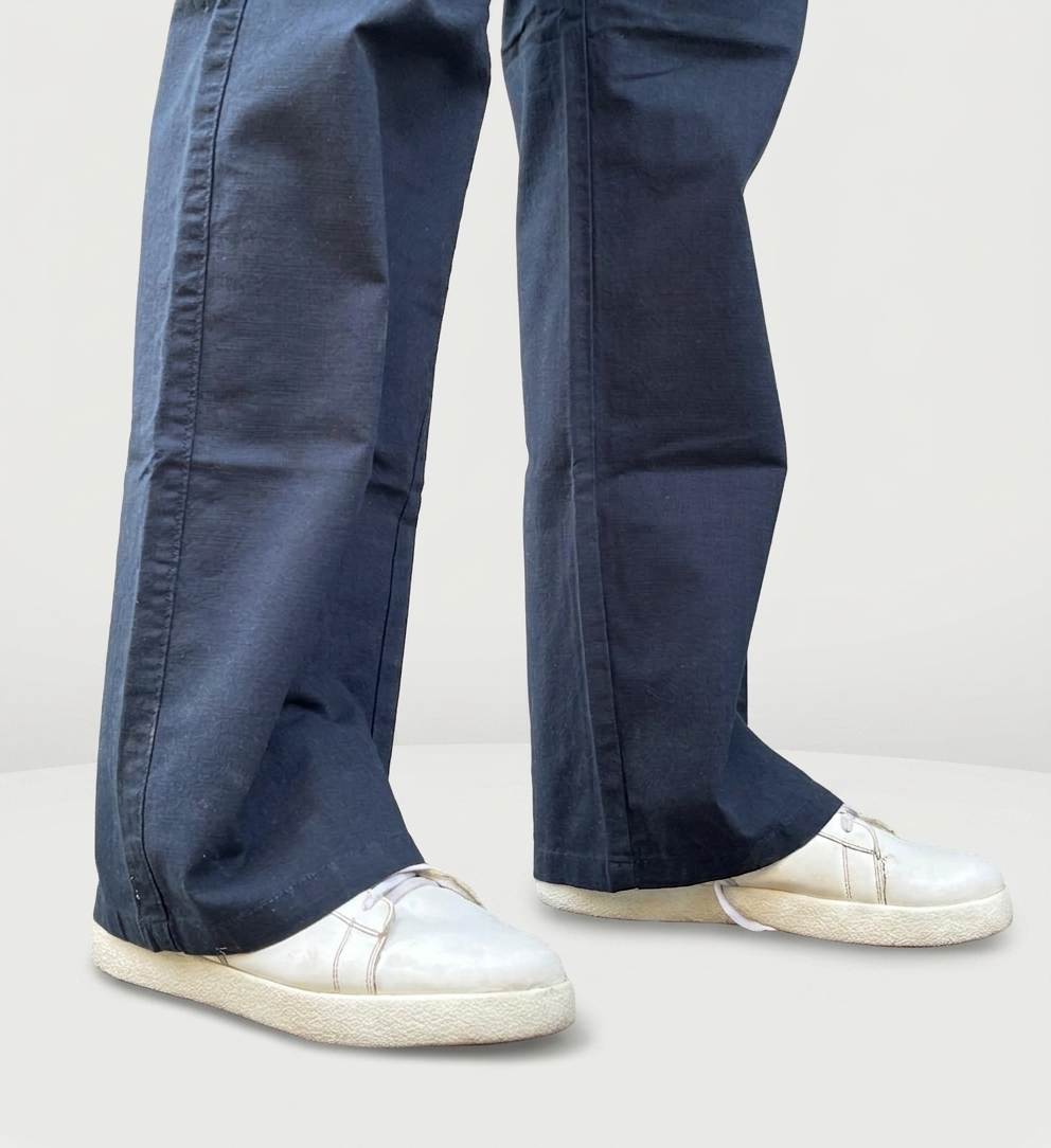 Close-up of navy drawstring trousers hem and tie, worn with white sneakers