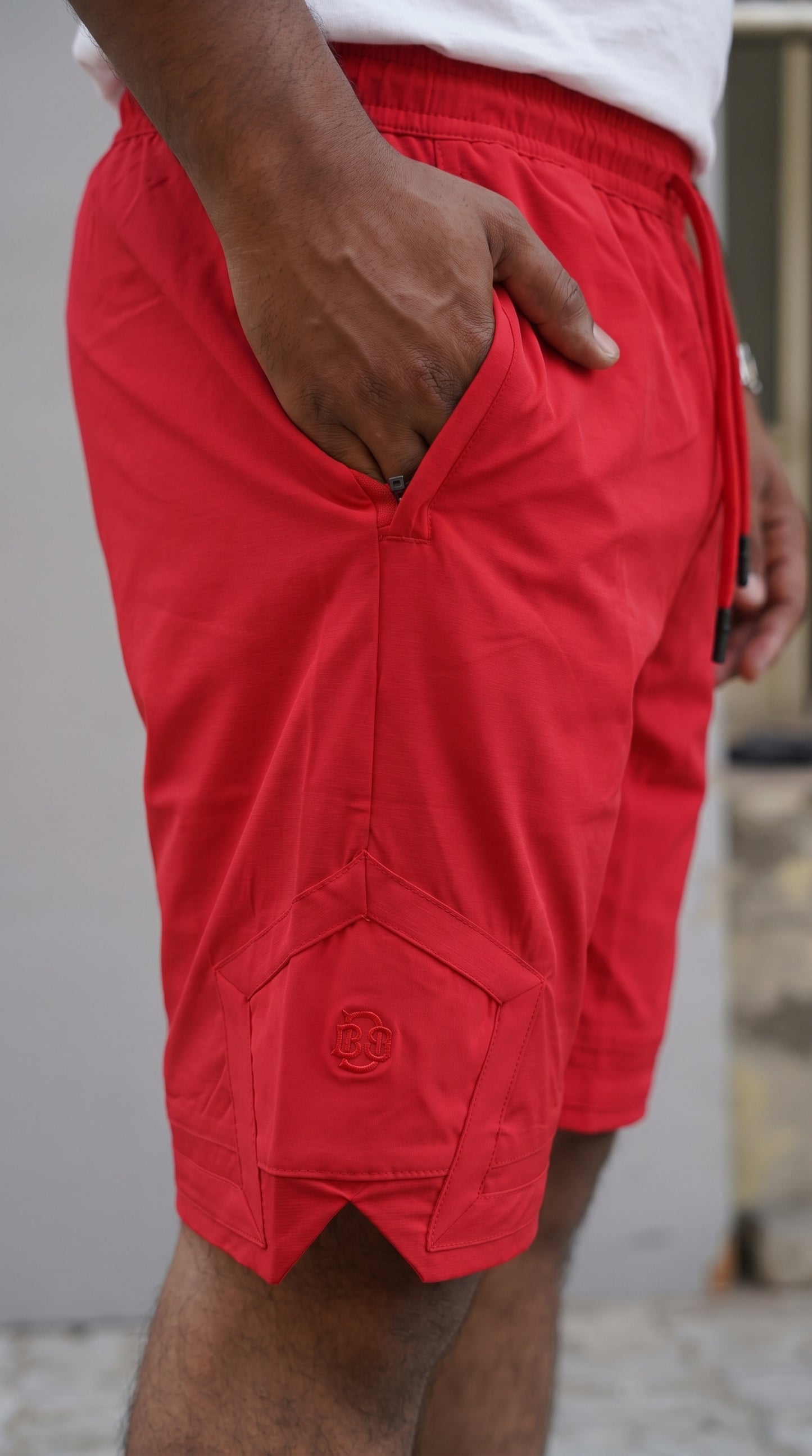 Red shorts front hem with embroidered logo and diagonal side seam pocket