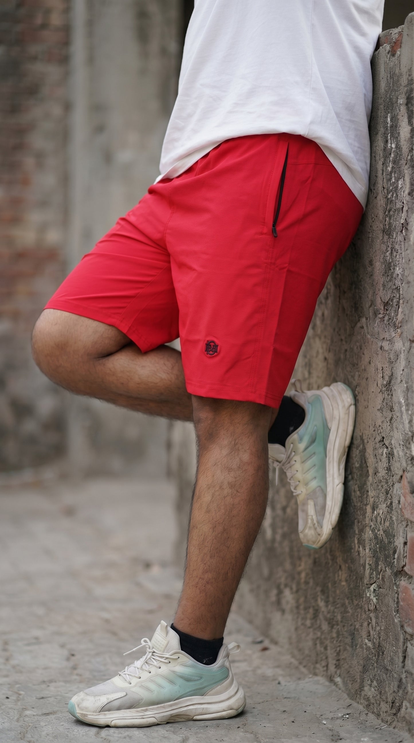 Red tech shorts with side seam and small logo, relaxed mid-thigh fit