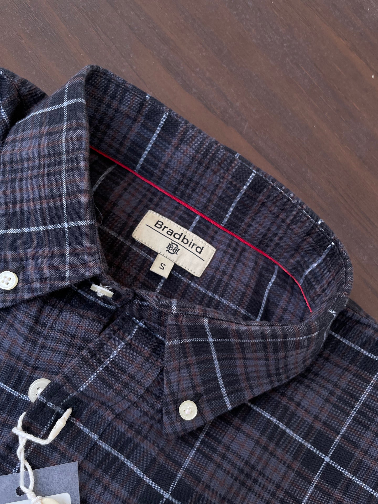 Oxford check button-up collar view, dark plaid with button placket and inner label