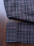 Oxford check shirt fabric close-up: sleeve cuff and hem, dark plaid with white grid